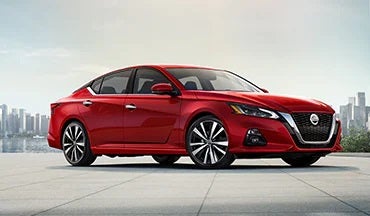2023 Nissan Altima in red with city in background illustrating last year's 2022 model in Rydell Nissan of Grand Forks in Grand Forks ND