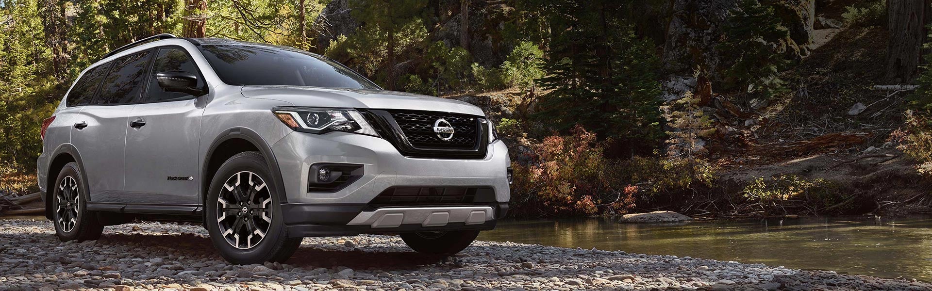 2021 Nissan Pathfinder next to a river in the woods