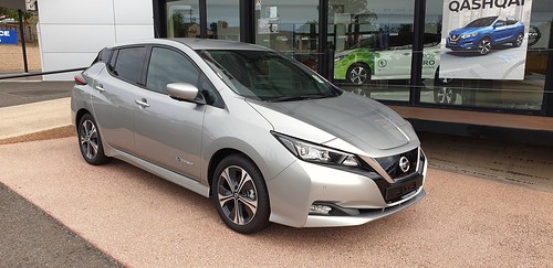 Silver Nissan car in front of international dealership