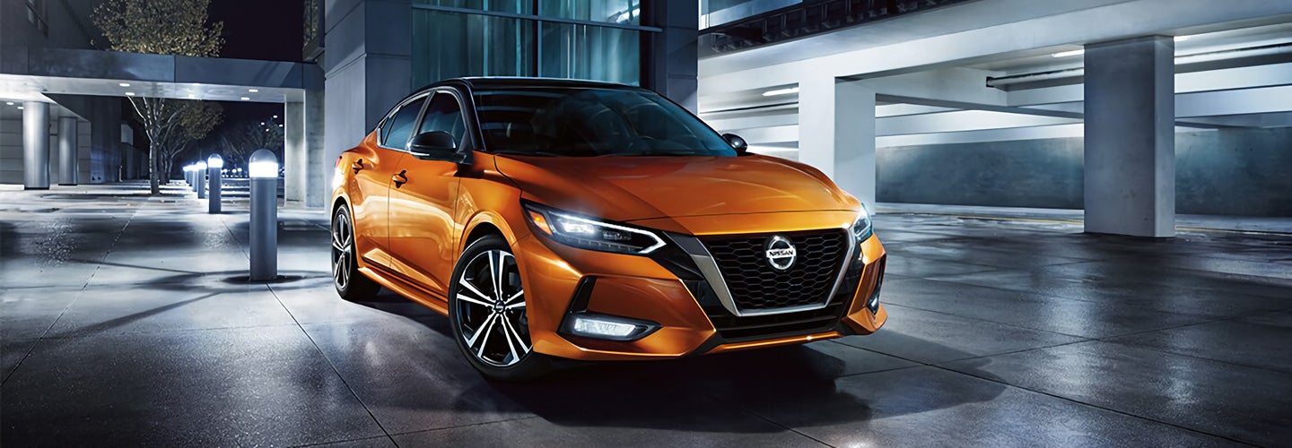 Orange Nissan Sedan pictures under a spotlight