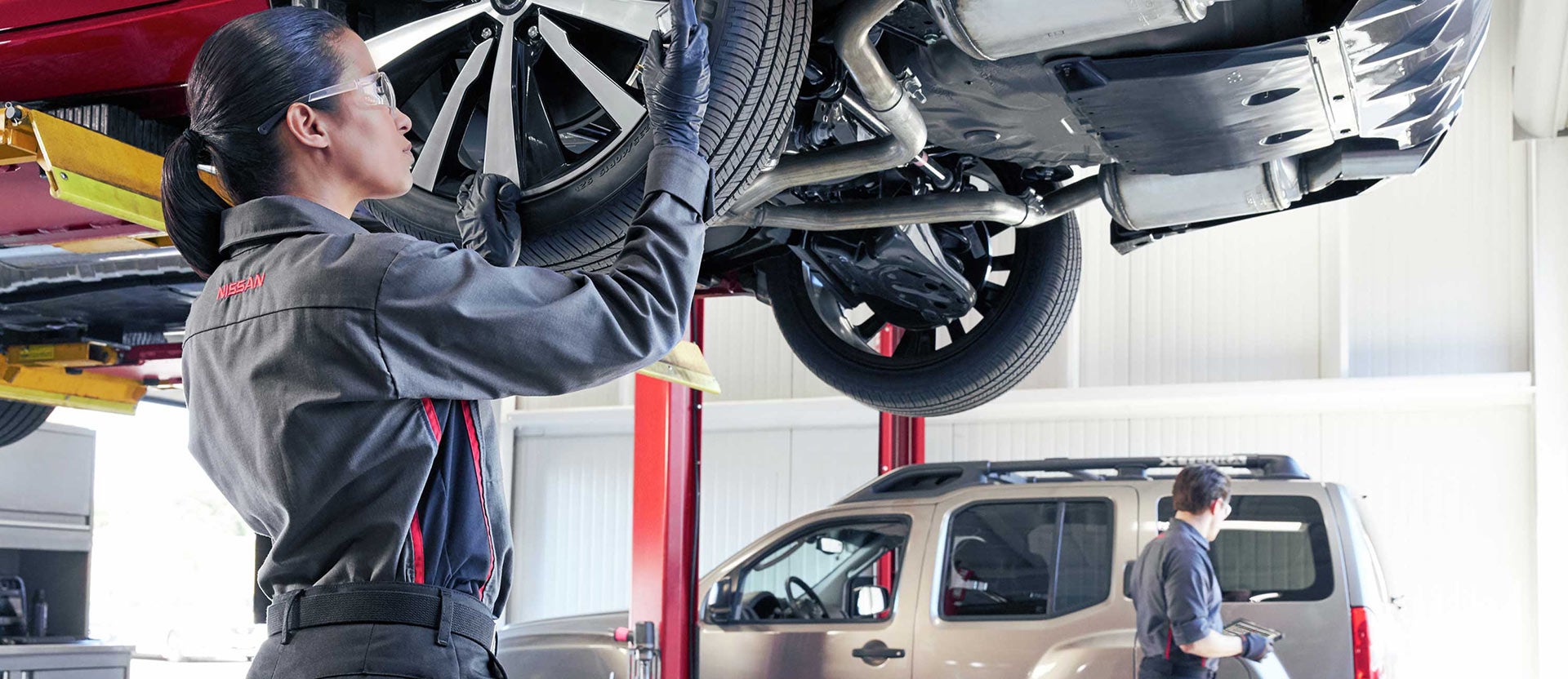 Nissan service professional checking the tires on a Nissan Rogue