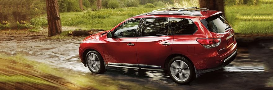 Red Nissan SUV driving on a burred background