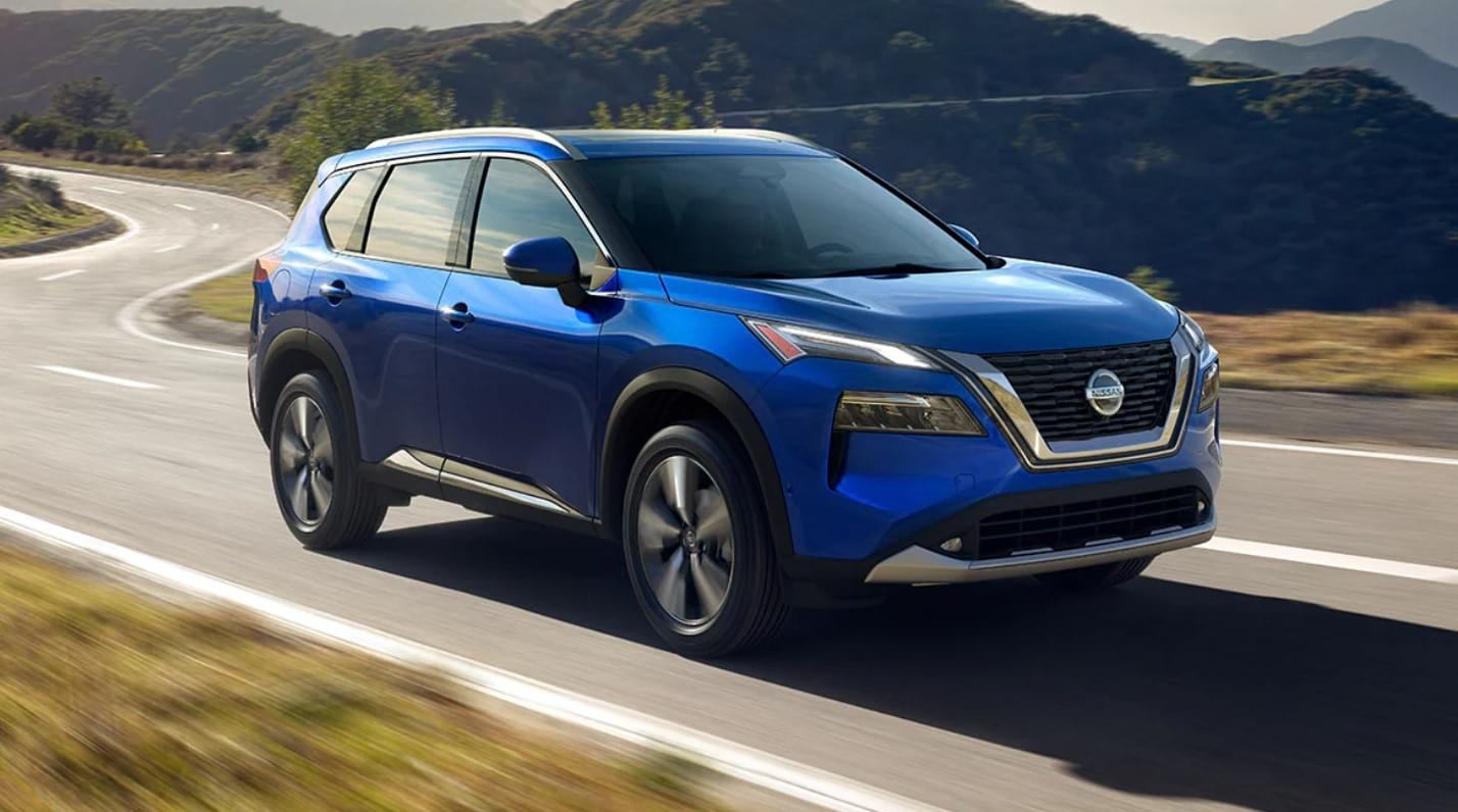Blue 2021 Nissan Rogue driving on a winding road