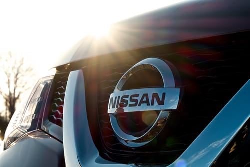 Close on Nissan logo on grille of Nissan vehicle with sun flare