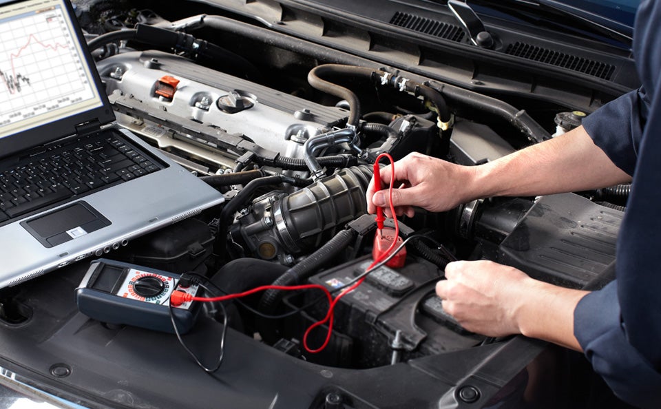 Auto technician diagnosing a car engine